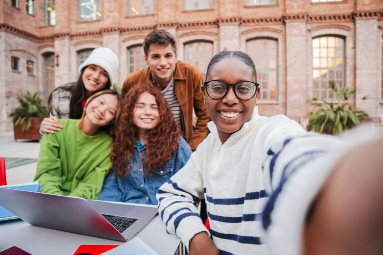African american teenage student taking a selfie with her friends using a smart phone. Group of